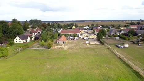 Marvelous-aerial-drone-flight-long-fly-backwards-drone-shot-of-a-farm-land-at
summer-sunset-on-a-lake-at-small-village-in-Brandenburg-Germany