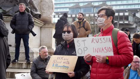 Pareja-De-Hong-Kong-Sosteniendo-Un-Mensaje-En-Ucrania-Activistas-De-Protesta-Contra-La-Guerra-En-Las-Calles-De-La-Ciudad-De-Manchester