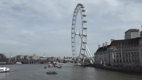 Una-Toma-Escénica-De-La-Impresionante-Rueda-De-La-Fortuna-Del-Ojo-De-Londres-Desde-El-Puente-De-Westminster-Con-Vistas-Al-Río-Támesis,-Una-Atracción-Turística-Icónica-Y-Popular,-Londres,-Inglaterra