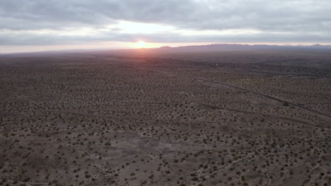 Aerial-view-of-the-sun-setting-behind-the-mountains-in-Arizona