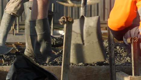Workers-Rubber-Boots-Standing-In-Wet-Cement-At-Slab-Construction-Site