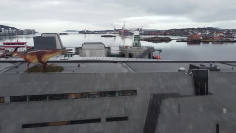 Approching-and-flying-over-Norwegian-oil-and-petroleum-museum-in-Stavanger---Dinosaur-on-roof---Forward-moving-aerial