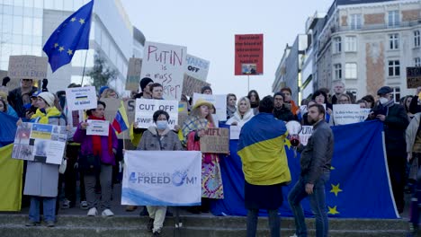 People-with-placards,-banners-and-flags-protest-at-the-Shuman-roundabout-in-the-heart-of-the-European-Union-quarter-in-Brussels