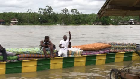 Un-Barco-De-Río-Largo-Con-Hombres-Felices-Que-Transportan-Colchones-En-Un-Río-Grande