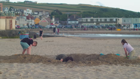 Kinder-Graben-Sand-Und-Genießen-Den-Sommer-Im-Badeort-Perranporth,-Cornwall,-Vereinigtes-Königreich