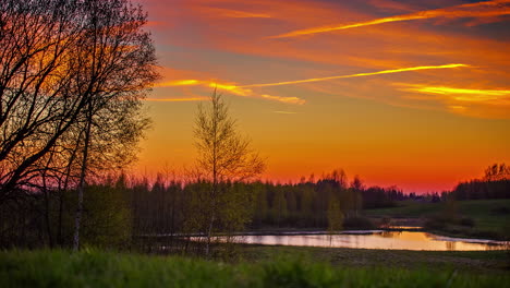 Zeitraffer-Einer-Wunderschönen-Parklandschaft-Mit-Ruhigem-See-Und-Orangefarbenem-Sonnenuntergang-Am-Himmel