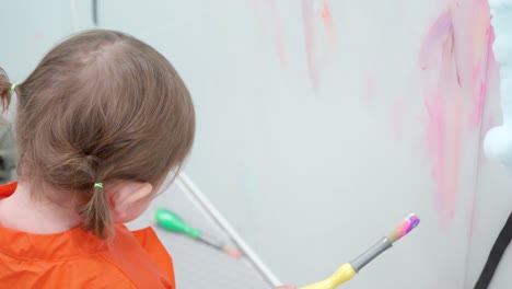Entzückendes-2-jähriges-Mädchen-Malt-An-Der-Wand-Eines-Spielzimmers-In-Einer-Kleinkindcafeteria