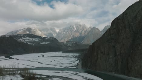 Drohnenaufnahme-Der-Hussaini-Hängebrücke-über-Den-Hunza-Fluss-In-Den-Bewölkten-Himalaya-Bergen