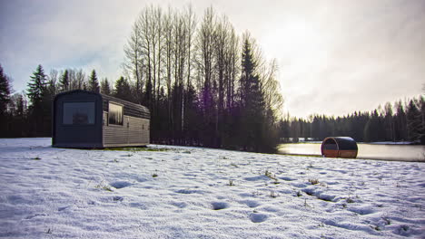 Time-lapse-of-snow-melting-revealing-green-grass-around-tiny-house-in-woods