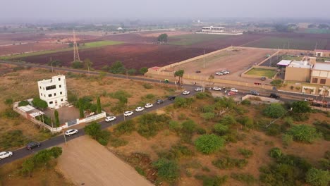 Poste-Eléctrico,-Vista-De-Campo-Verde-De-La-Aldea-Rural-Donde-Los-Camiones-Se-Mueven-Por-La-Carretera-Pavimentada