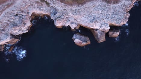 Luftaufnahme-Von-Oben-Nach-Unten-Von-Wellen-Gegen-Felsige-Küste,-Hintergrund