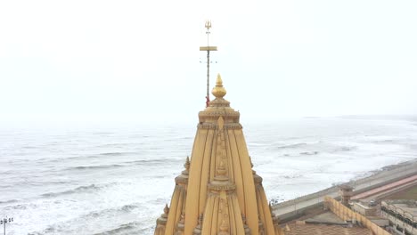 Tiro-Giratorio-De-Drones-Aéreos-De-Somnath-Mandir-Con-Paisaje-Urbano-Y-Mar-En-El-Fondo