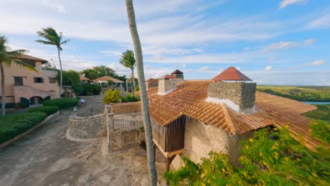 Aerial-flyover-historic-village-named-Altos-de-Chavon-with-tourist-during-sunny-day-and-Rio-Chavon-in-valley