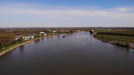 Vista-Aérea-De-Un-Dron-Barco-Cisterna-Motor-Da-Vinci-En-La-Distancia-Acercándose-A-Lo-Largo-De-Oude-Maas