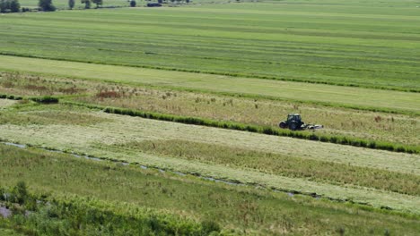 Einsamer-Traktor,-Der-In-Endlosen-Grünen,-Lebendigen-Ackerlandfeldern-Arbeitet,-Luftaufnahme-Der-Umlaufbahn