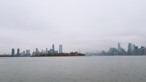 Lapso-De-Tiempo-Del-Río-Hudson-Y-La-Isla-De-Ellis-Con-El-Horizonte-De-Manhattan-En-El-Fondo