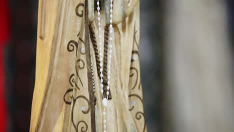 Close-up-panning-shot-of-small-Virgin-Mary-statue-kept-in-table-of-church
