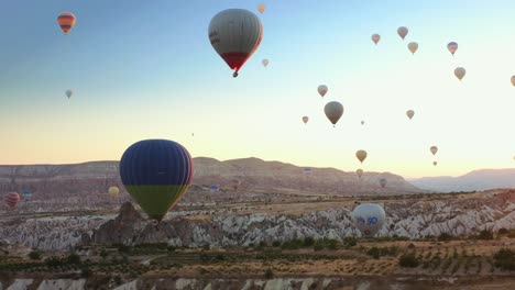 Luftdrohnenansicht-Des-Bunten-Heißluftballons,-Der-Bei-Sommerlichem-Sonnenaufgang-über-Kappadokien-Fliegt