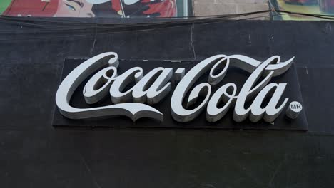 Cartel-De-Coca-Cola-Contra-Fondo-Negro-En-Un-Centro-Refrescante-En-La-Ciudad-De-México