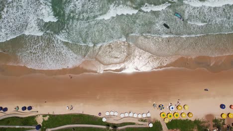 Topdown-dolly-kitesurfer-on-waves-at-Brazilian-coastline,-Natal