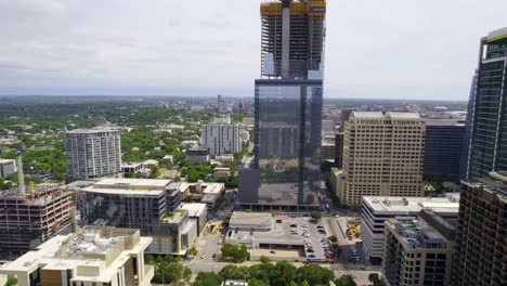 Aerial-view-revealing-a-high-rise-construction-site,-in-Austin,-USA---pan,-drone-shot
