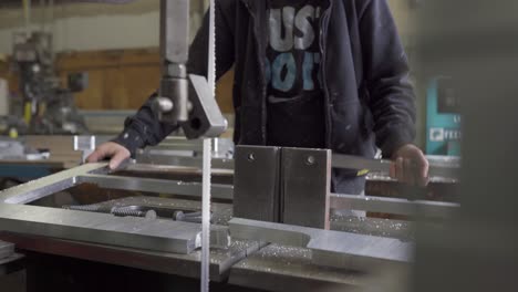 Trabajador-Cortando-Aluminio-En-Una-Sierra-De-Cinta,-Industria-De-Fabricación-De-Metales