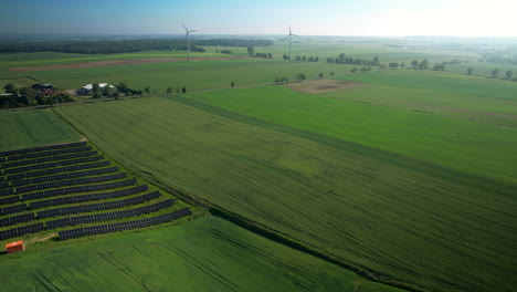 Sonnenkollektoren-Und-Windkraftanlagen-Auf-Einem-Riesigen-Grünen-Feld,-Luftaufnahme