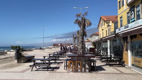Menschen-Vor-Dem-Café-Am-Meer,-Furadouro-Strand,-Sonniger-Frühlingstag