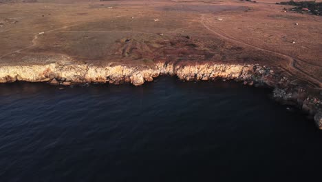 Drohne-Von-Oben-Nach-Unten-Luftaufnahme-Von-Wellen,-Die-Gegen-Die-Felsige-Küste-Spritzen,-Hintergrund