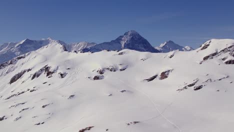 Aerial-winter-drone-footage-bottom-up-revealing-Fiescherhoerner,-Eiger-North-Face-and-Jungfrau-in-Switzerland