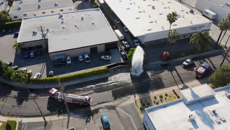 Luftaufnahme-Eines-Feuerwehrautos,-Das-Einen-Hydrantenausbruch-Beruhigt,-Im-Orbit-Von-Los-Angeles,-Drohnenaufnahme