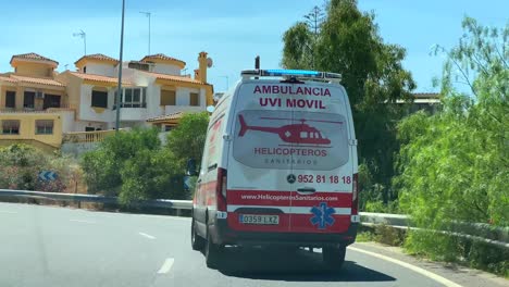 Emergency-ambulance-driving-fast-on-the-highway,-saving-lives,-rushing-to-the-hospital-in-Marbella-Malaga-Spain,-4K-action-shot