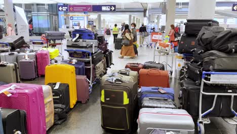 Verzweifelter-Passagier-Durchstöbert-Am-Flughafen-Verlassene-Gepäckstücke-Auf-Der-Suche-Nach-Seinem-Eigenen-Gepäck