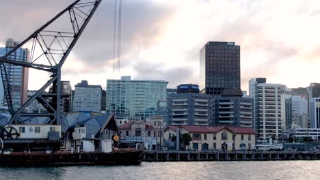 People-walking-and-wandering-along-the-waterfront-against-the-city-office-block-landscape-in-capital-Wellington,-New-Zealand-Aotearoa