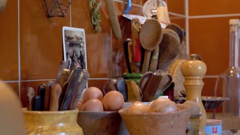 Estación-De-Preparación-De-Alimentos-De-Cocina-En-Una-Villa-Con-Huevos,-Cebollas,-Especias,-Cuchillos-Y-Utensilios,-Primer-Plano-De-La-Derecha-De-La-Muñeca