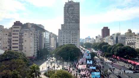 Flying-over-9-of-July-Avenue,-Buenos-Aires-Argentina,-Demonstration-Protesters-in-the-Street-next-to-Ministry-of-Social-Development-District,-Panning-View