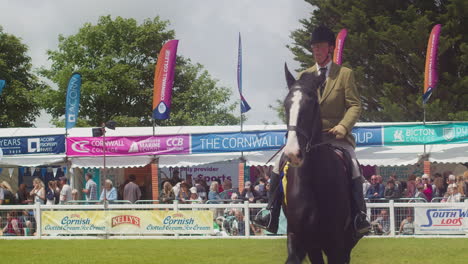Die-Royal-Cornwall-Show-2022-Mit-Einem-Männlichen-Jockey-Und-Einem-Preisgekrönten-Pferd-Beim-Reiten-Und-Menschen-Im-Hintergrund