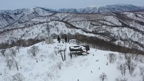 Skifahrer-Mit-Dem-Skilift-Kommen-Im-Winter-Am-Schneebedeckten-Berggipfel-In-Nozawa-Onsen-In-Nagano,-Japan-An