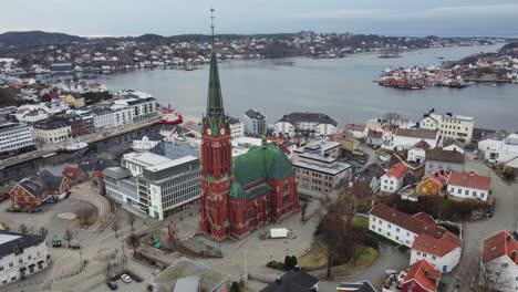 Dreifaltigkeitskirche-Arendal-Norwegen-Schöne-Umlaufende-Luftaufnahme---Riesige-Kathedrale-Mit-Meer--Und-Stadthintergrund