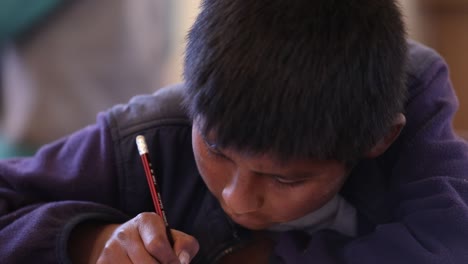 A-boy-in-an-elementary-school-in-Bolivia-writes-in-his-school-notebook-in-the-Bolivian-Andes-Mountains