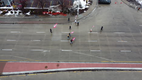 Grupo-De-Camioneros-Con-Banderas-Canadienses-Marchando-En-La-Calle-Durante-La-Protesta-Del-Convoy-De-La-Libertad-En-Windsor,-Ontario,-Canadá