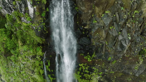Close-up-vertical-drone-ascent-down-Veu-da-Noiva-waterfall-in-Seixal,-Madeira