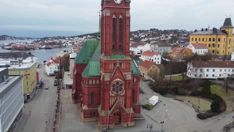 Trinity-church-Arendal-ascending-aerial-from-ground-level-to-top-of-tower---Aerial-starting-from-main-entrance-before-slowly-moving-upwards---Norway