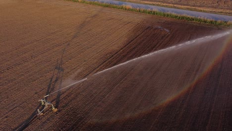 Luftaufnahme-Der-Bewässerung-In-Braunem-Landwirtschaftlichen-Boden,-Bewässerungsgeräte-Auf-Dem-Landwirtschaftlichen-Feld-In-Cingoli,-Macerata,-Italien
