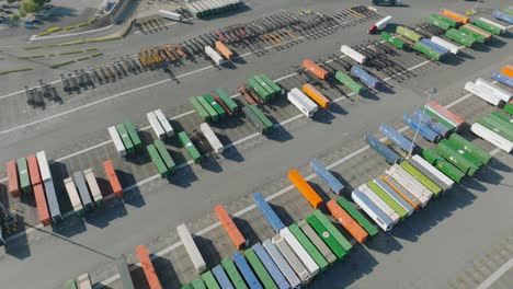 Aerial-Drone-Footage-of-Train-Shipping-Containers-Lined-Up-in-LA-Rail-Yard,-Colorful-Boxcars-on-Pavement