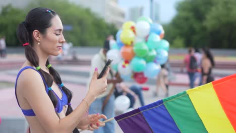 Ein-Video-Einer-Schönen-Dame-Mit-Einer-Regenbogenfahne,-Die-Mit-Ihrem-Handy-Fotos-Bei-Der-LGBT-Pride-Parade-Macht