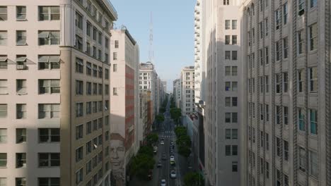 Flug-über-Die-Straßen-Der-Innenstadt-Von-Los-Angeles,-Wunderschöne-Drohnenaufnahme-Mit-Stadtgebäuden-Auf-Beiden-Seiten