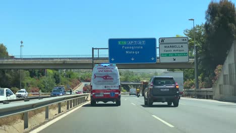 Emergency-ambulance-driving-fast-on-the-highway,-saving-lives,-rushing-to-the-hospital-in-Marbella-Malaga,-Spain,-4K-action-shot
