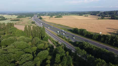 Aerial-view-countryside-agricultural-rural-farmland-in-Rainhill-and-busy-M62-motorway-traffic-pan-left