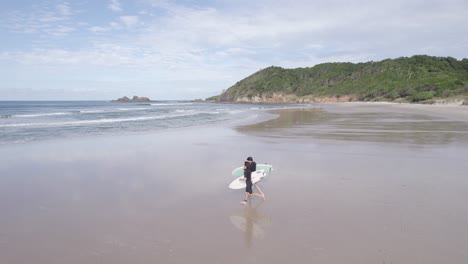 Zwei-Junge-Männliche-Surfer-Mit-Surfbrett-Laufen-Am-Strand-Zum-Meer,-Um-Zu-Surfen-–-Gebrochener-Kopf,-New-South-Wales,-Australien